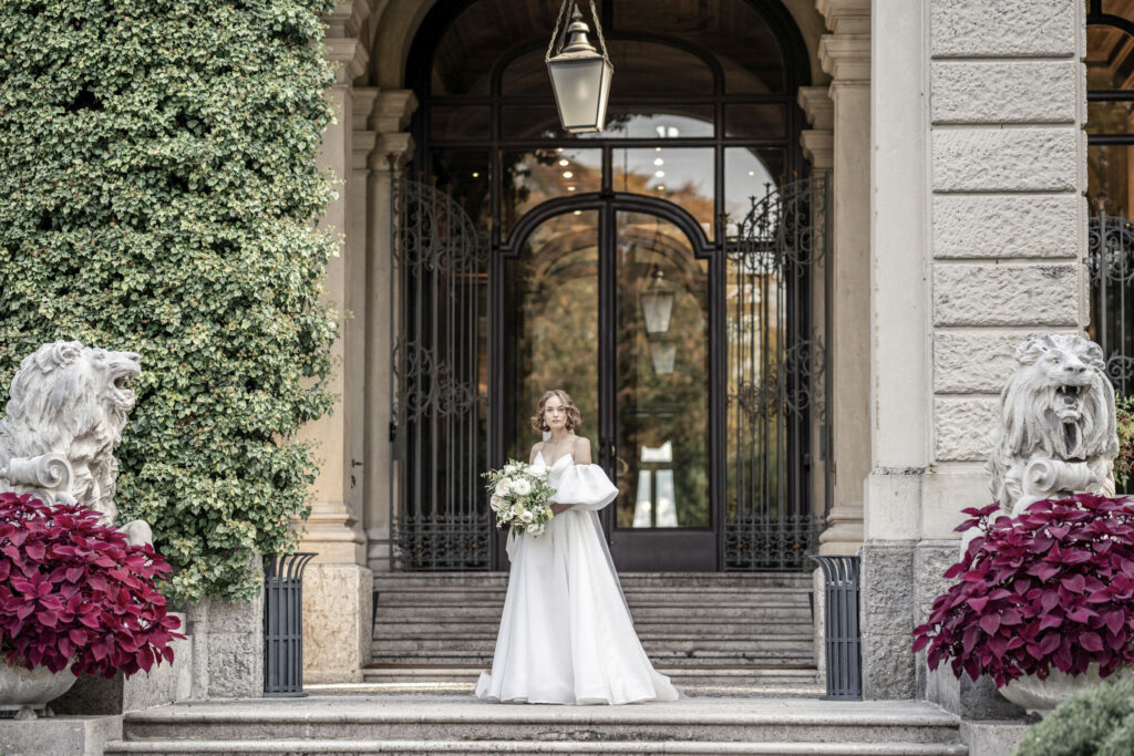 A bridal model standing outside of the front entrance of Villa Erba for a styled wedding shoot.