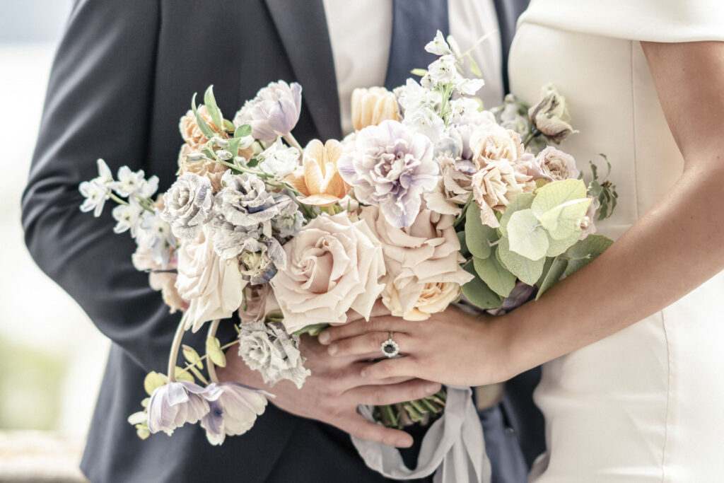 A close up of bride and groom models holding a bouquet.